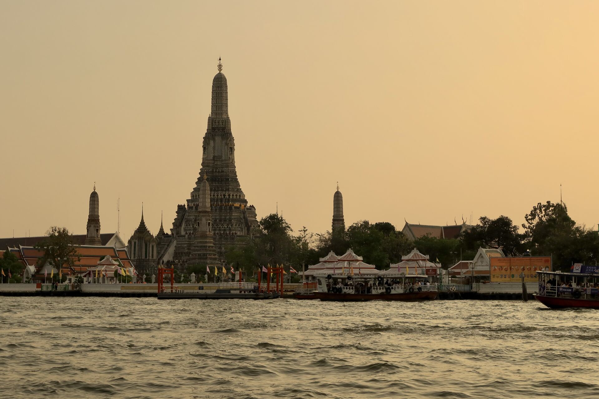 A bangkoki Wat Arun templom sziluettje naplementében, a Csao Phraja folyó partján.